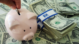 Pink piggy bank on top of US dollar bills